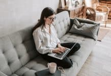Kvinde arbejder på computer i sin sofa